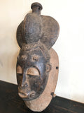 Strange Imports African Art Portrait Mask (Gba gba) Baule peoples Cote d'Ivoire Carved Wood Mblo tradition Lustrous carved surfaces suggest healthy skin set off by a delicately textured coiffure and facial scarifications.