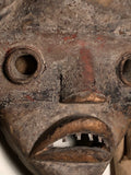 Bu Gle mask Dan Culture Liberia 20 th c. 10” x 8” x 3.5 “  Carved wood , earth paints, natural fibers , cloth and metal.  the Bu Gle mask of the Warrior round, projecting eyes mouth with metal teeth designed to be deliberately frightening.