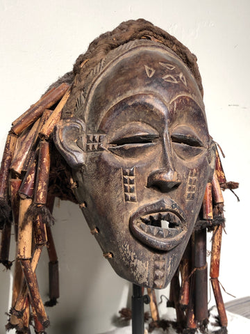 T schokwe Mask mwana pwo  Zaire  early 20th century   Carved Wood, fiber, beaded adornment.  9” x 12” x 15” tall  A popular and frequent occurrence in entertainment masquerades, mwana pwo represents a female ancestor but is always worn by a male dancer. This mask type symbolizes fecundity and the prominent role of women in Chokwe society
